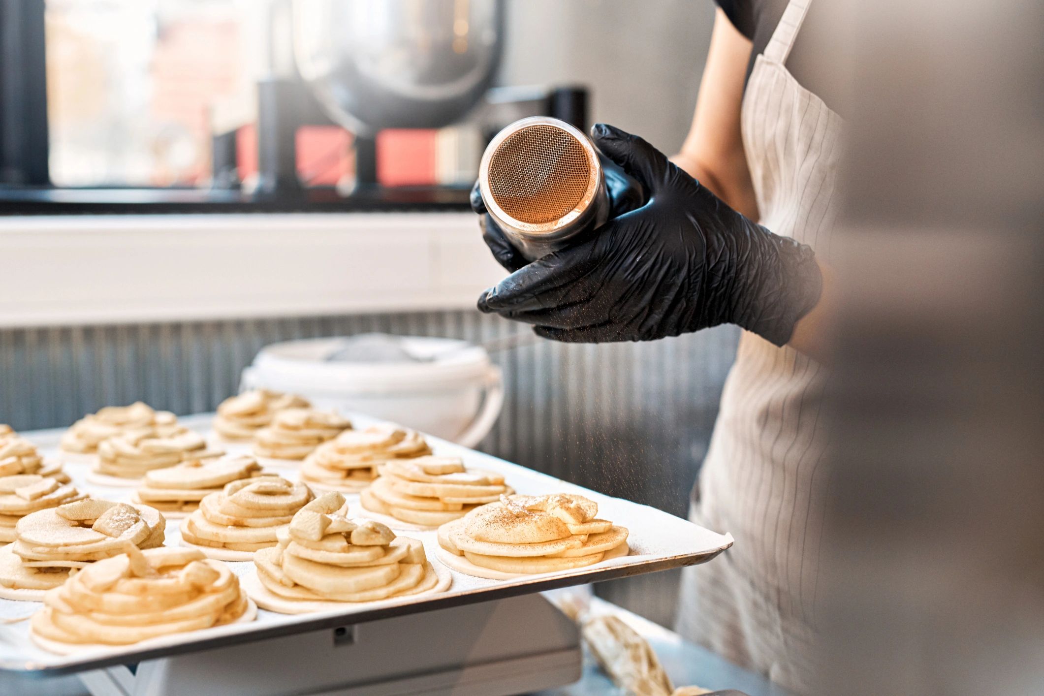 Baker adding finishing touches to cakes in a bakery kitchen