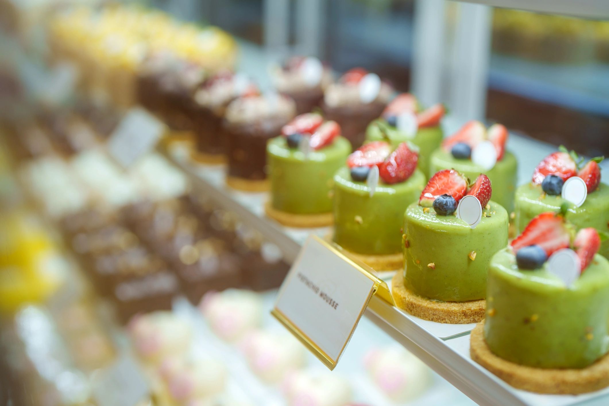 Cakes and desserts displayed in a bakery refrigerator case