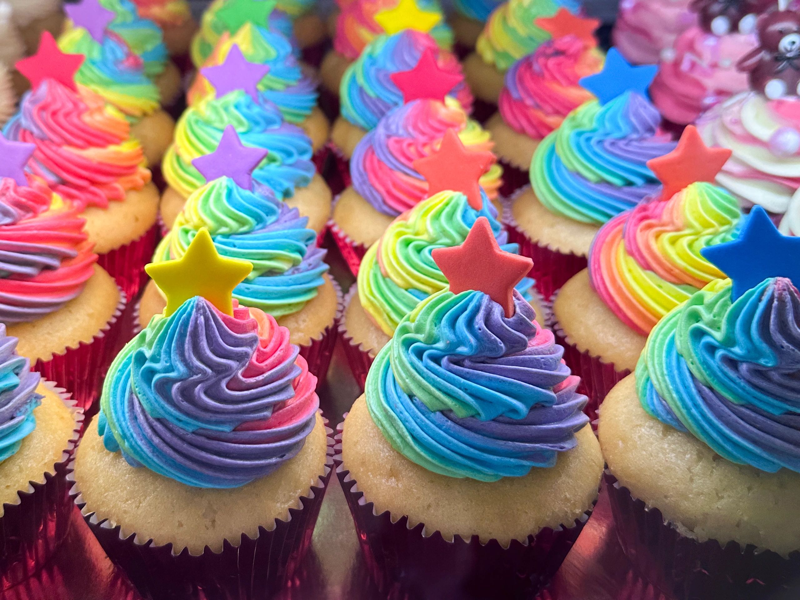 Assortment of rainbow cupcakes with buttercream icing
