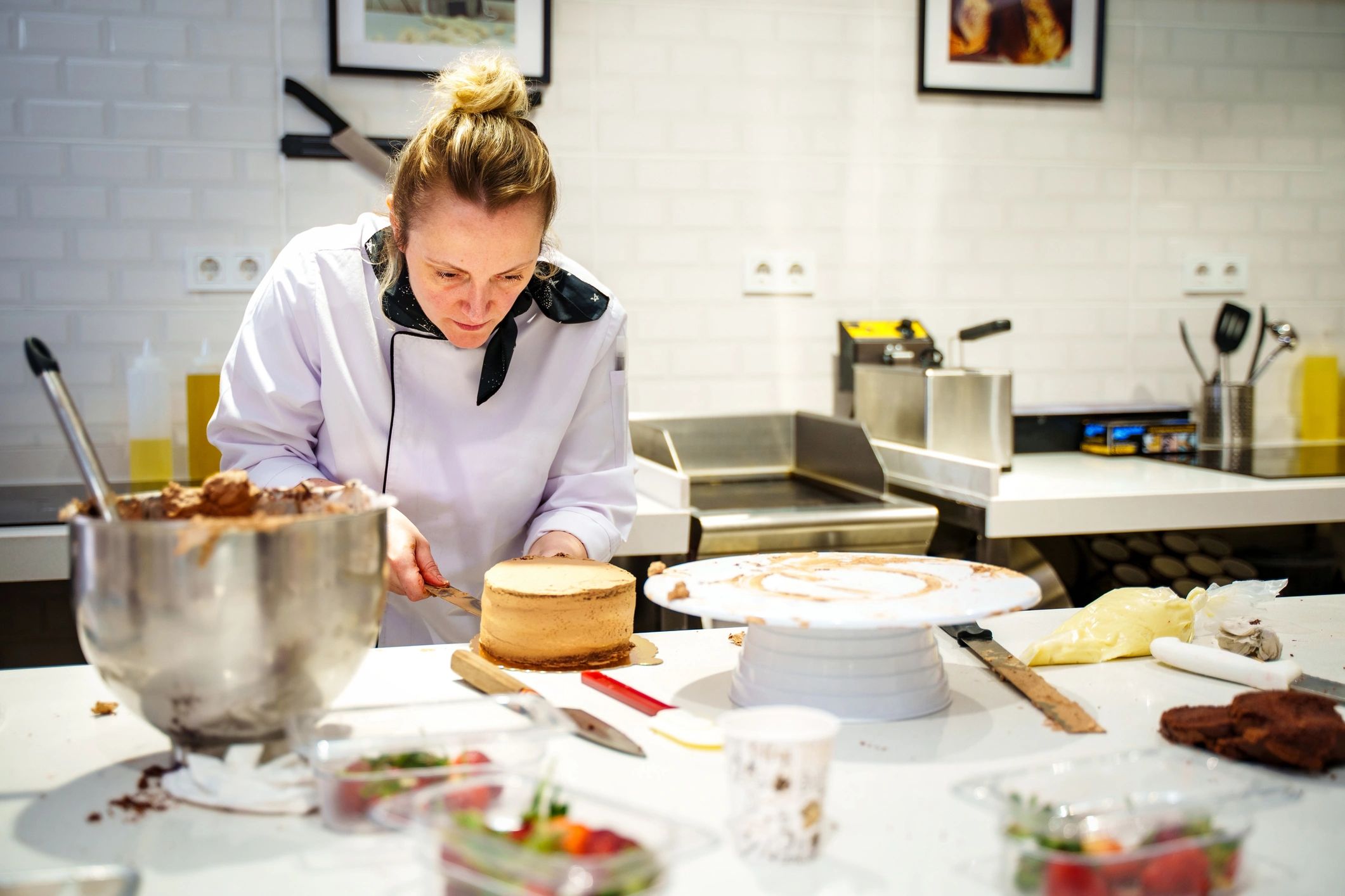 Pastry chef decorating a cake with frosting