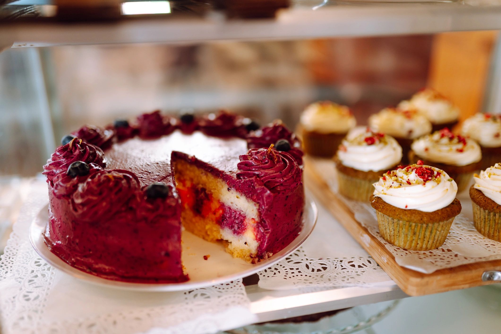 Colorful cakes and cupcakes displayed in a bakery window