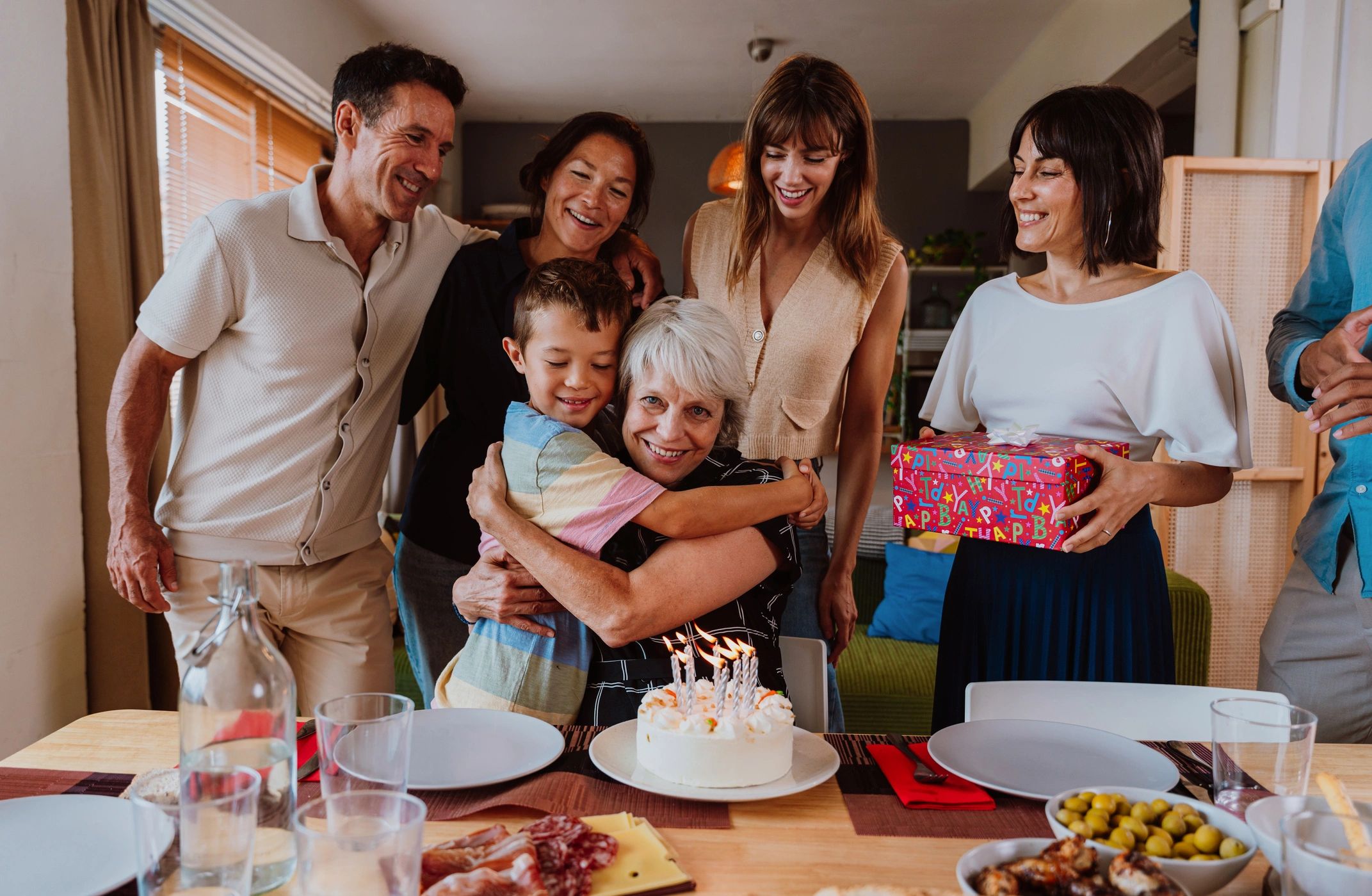 Multi-generational family gathered around a table for a birthday celebration