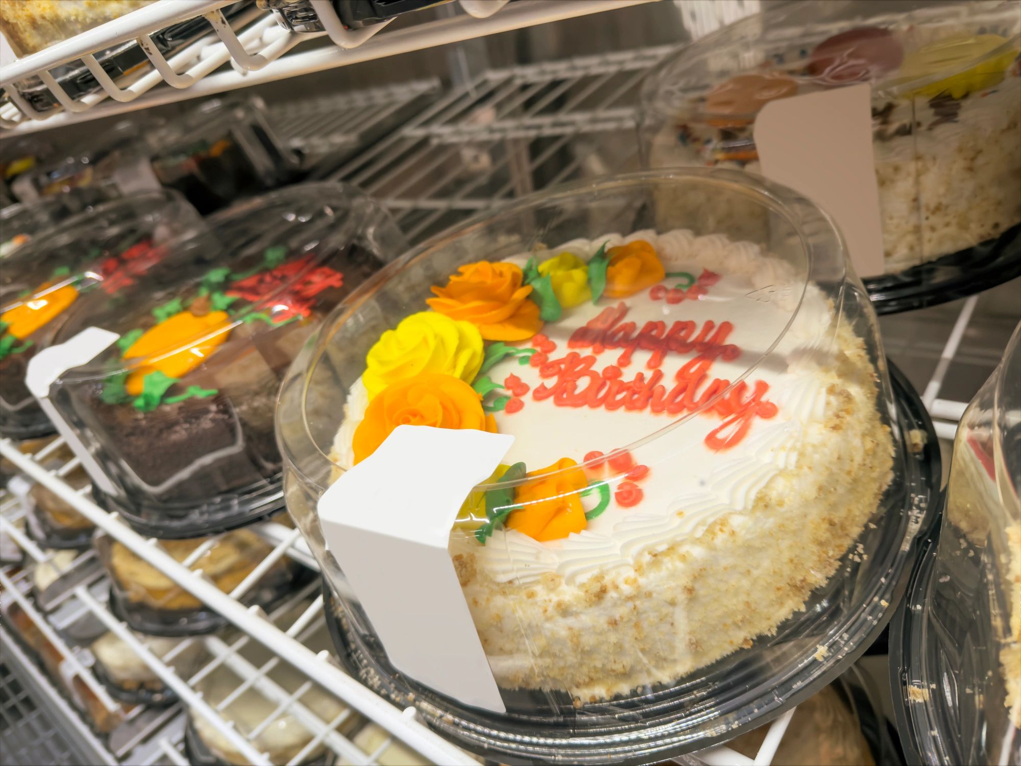 Assorted decorated cakes on bakery display shelves